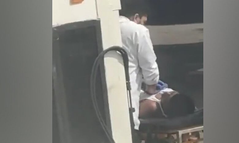 A doctor performing CPR on an unconscious migrant worker on a stretcher after an emergency landing at Mumbai airport.