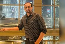VP Shameer Medon, UAE-based Indian businessman, photographed indoors with a city skyline in the background.