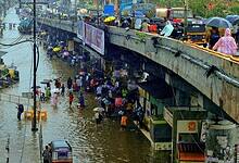 Commuters make way through a waterlogged road amid rainfall in Palghar in Maharashtra. (PTI Photo)