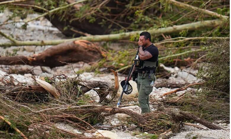 A police officials stands amid debris due floods in Texas