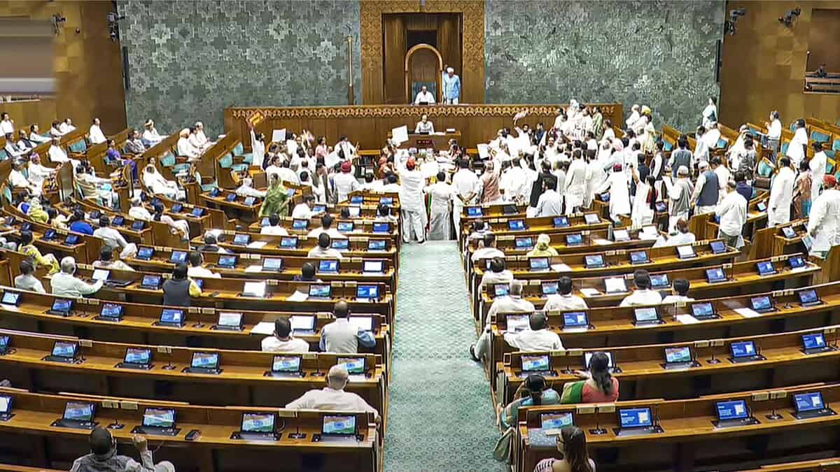 Opposition members protest in the well of the Lok Sabha during the Monsoon session of Parliament in New Delhi on Wednesday. (Sansad TV via PTI Photo)