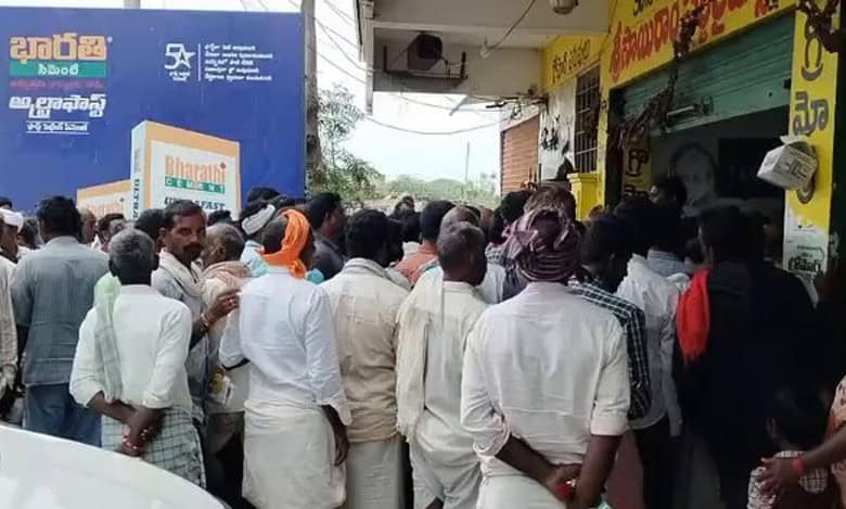 Farmers wait for their turn to receive urea in Pulkal village, Sangareddy