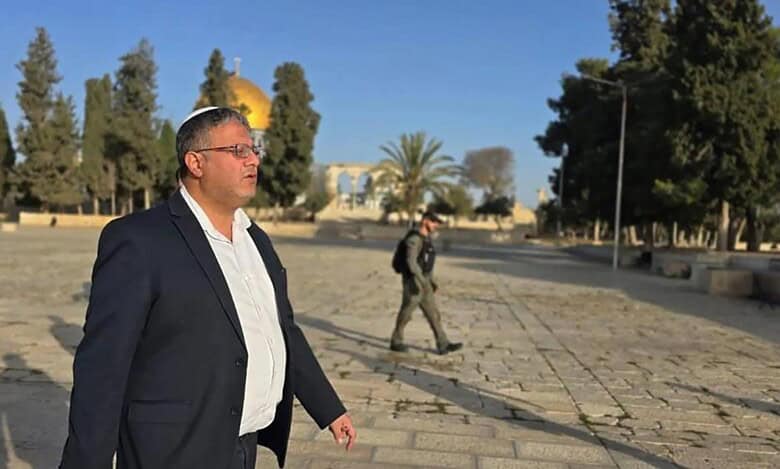 Israeli National Security Minister Itamar Ben-Gvir walks at Al-Aqsa Mosque compound under police guard, with Dome of the Rock in the background.