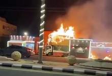 A burning truck near a petrol station in Saudi Arabia, with flames rising from its cabin.