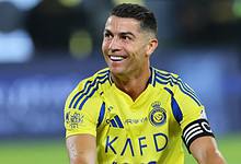 Football star Cristiano Ronaldo in Al Nassr yellow jersey smiling during match.