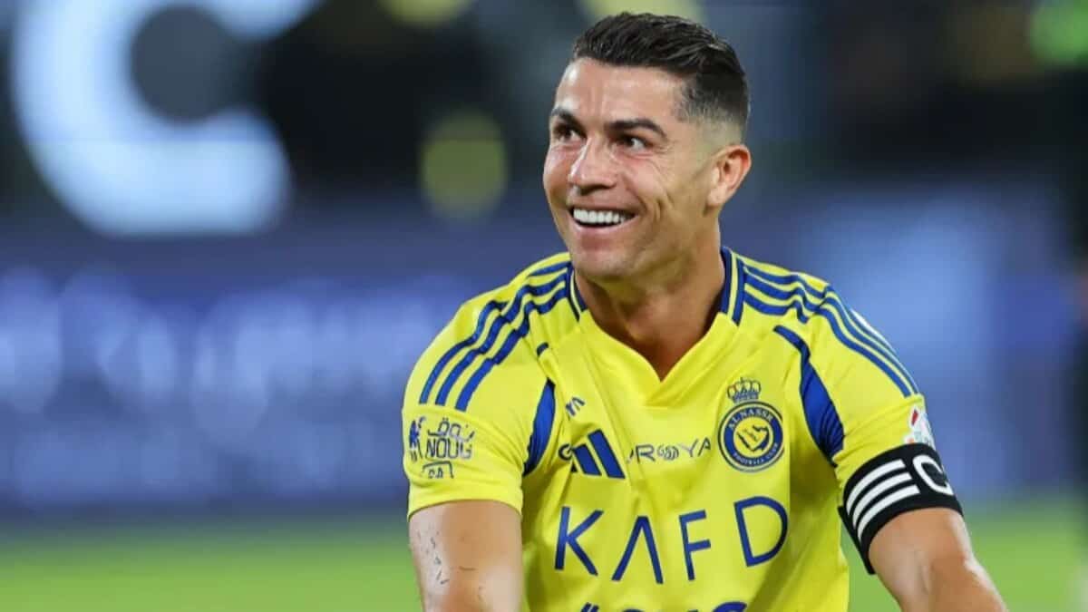 Football star Cristiano Ronaldo in Al Nassr yellow jersey smiling during match.