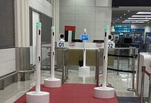 AI-powered passenger corridor at Dubai Airport with multiple biometric scanning stations on a red carpet.