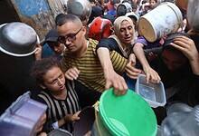 Palestinian families struggle to receive food aid at a crowded distribution point in Nuseirat refugee camp, central Gaza Strip, amid deepening famine.