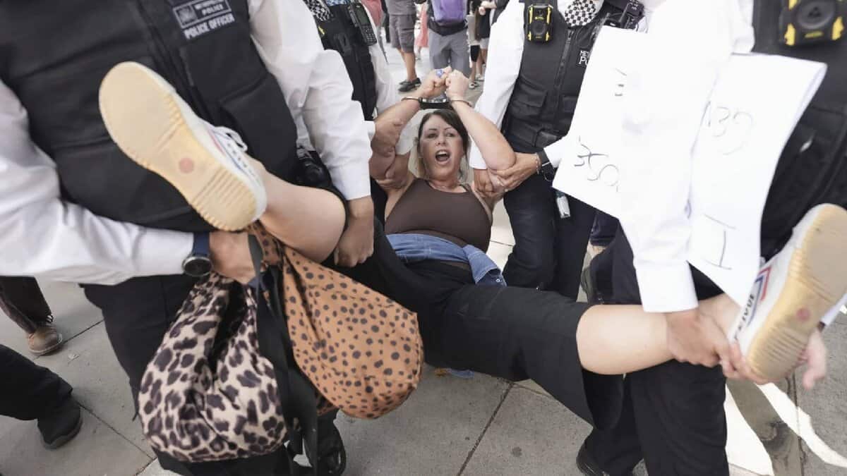 Police officers carry a protesting woman during a pro-Palestine Action demonstration in Parliament Square, London.