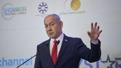 Israeli Prime Minister Benjamin Netanyahu gestures while addressing an audience at a political event.