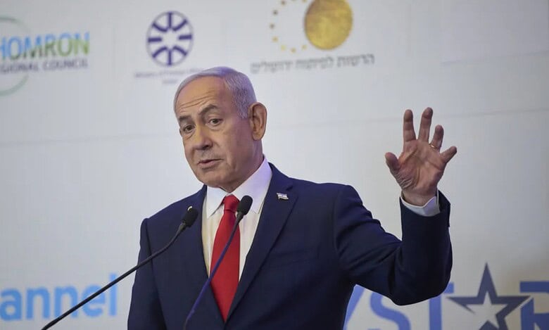 Israeli Prime Minister Benjamin Netanyahu gestures while addressing an audience at a political event.