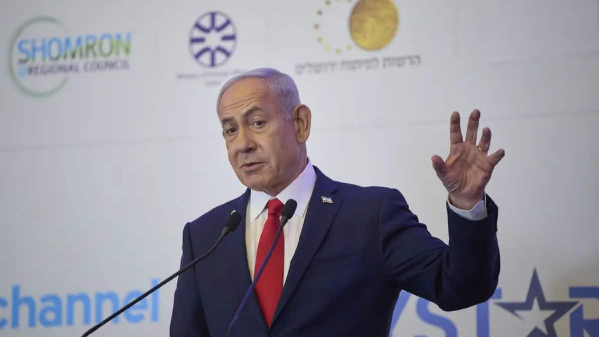 Israeli Prime Minister Benjamin Netanyahu gestures while addressing an audience at a political event.