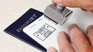 Immigration officer stamping a passport for visa clearance.