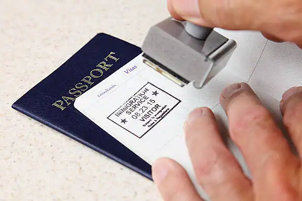Immigration officer stamping a passport for visa clearance.