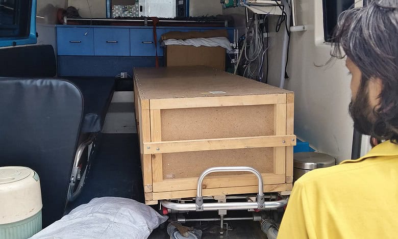 Wooden coffin box inside ambulance carrying mortal remains of Telangana migrant.