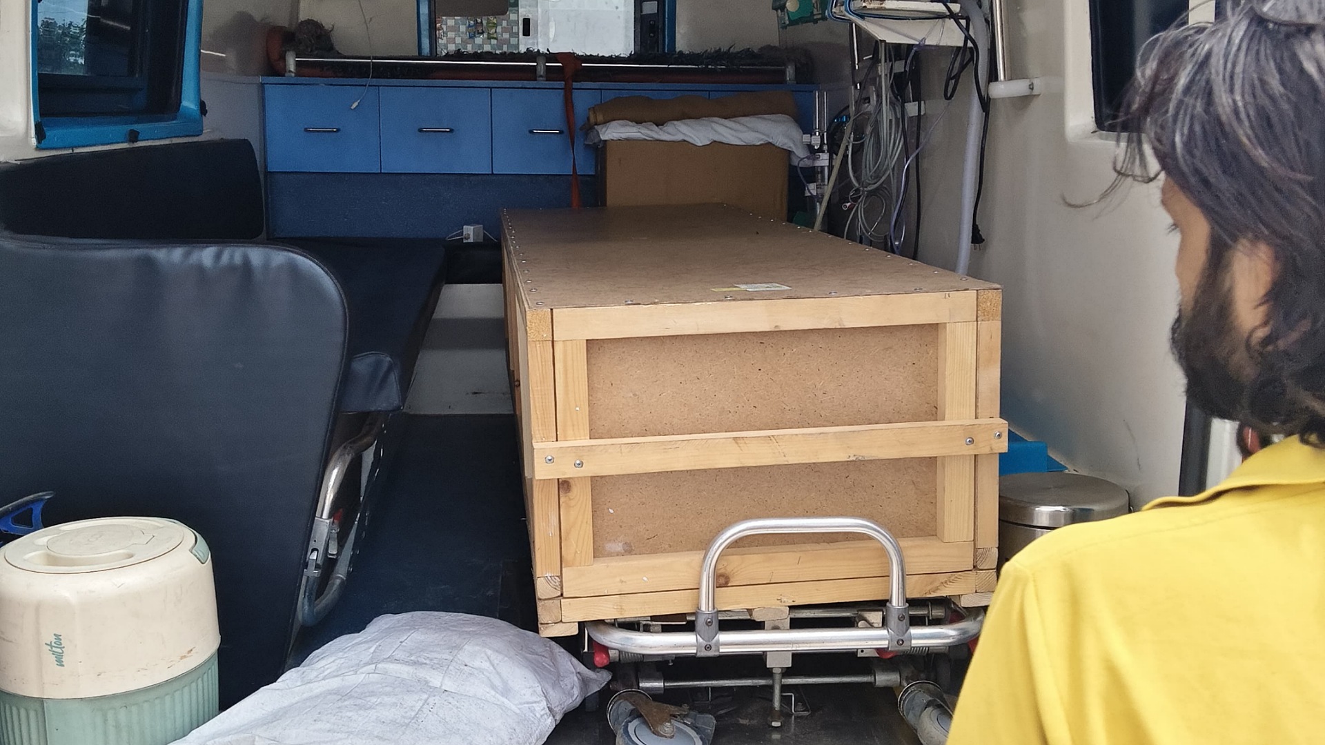Wooden coffin box inside ambulance carrying mortal remains of Telangana migrant.