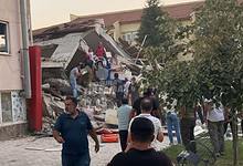 People gather near a collapsed building in Balıkesir, Turkey, after a 6.1-magnitude earthquake.