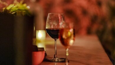 Glasses of wine on a dimly lit table with candlelight.