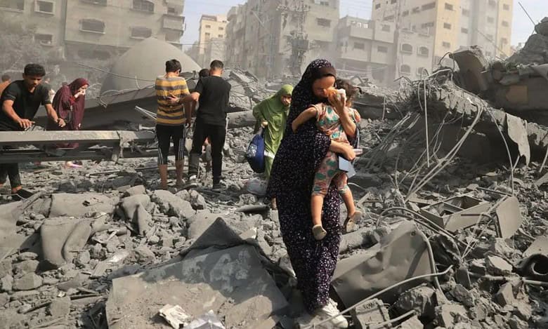 People walk through rubble and dust after Israeli air strikes destroyed buildings in Gaza City.