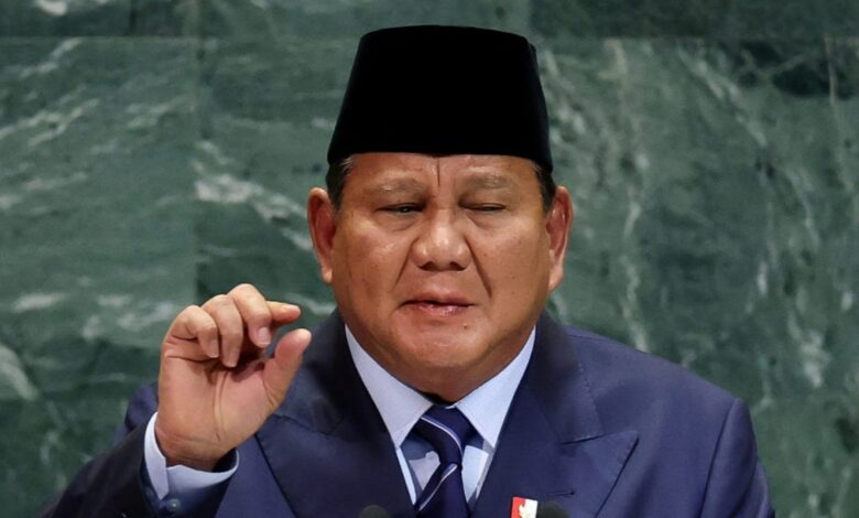 Indonesian President Prabowo Subianto, wearing a dark suit, striped tie, and traditional black peci hat, addresses the United Nations General Assembly.