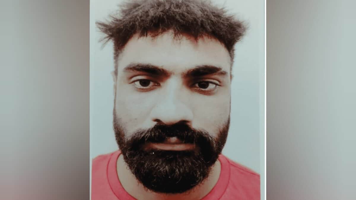 Close-up mugshot of Parminder Singh with a beard, short messy hair, and wearing a red shirt.