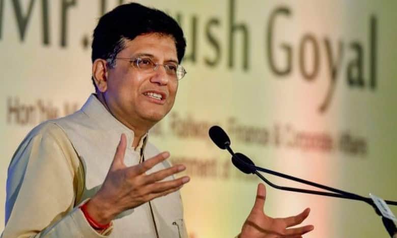 Piyush Goyal speaking at an event, gesturing with his hands near a microphone.