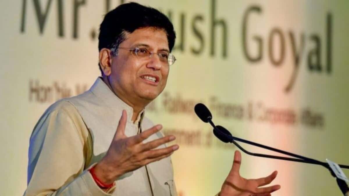 Piyush Goyal speaking at an event, gesturing with his hands near a microphone.