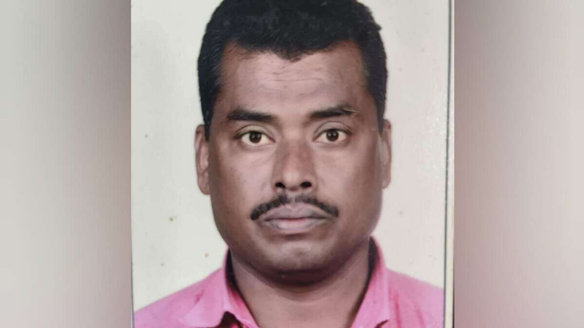 A passport-style photograph of Mohammad Rafi, a 50-year-old Indian man from Telangana with short black hair, a thin mustache, and a serious expression, wearing a pink collared shirt against a plain gray background.