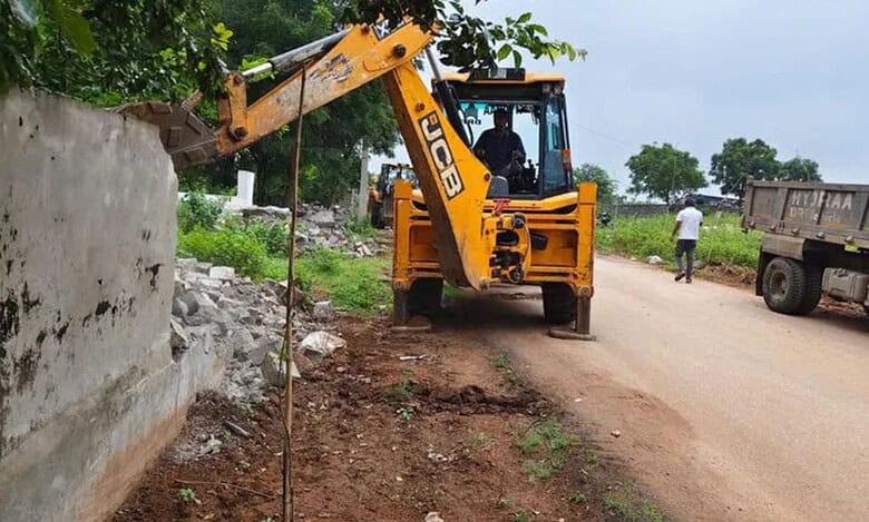 Boundary wall on a government land being demolished in Shamshabad