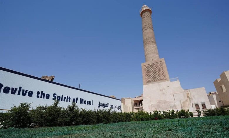 Restored al-Hadba minaret of Mosul’s al-Nuri mosque with a banner reading “Revive the Spirit of Mosul.”
