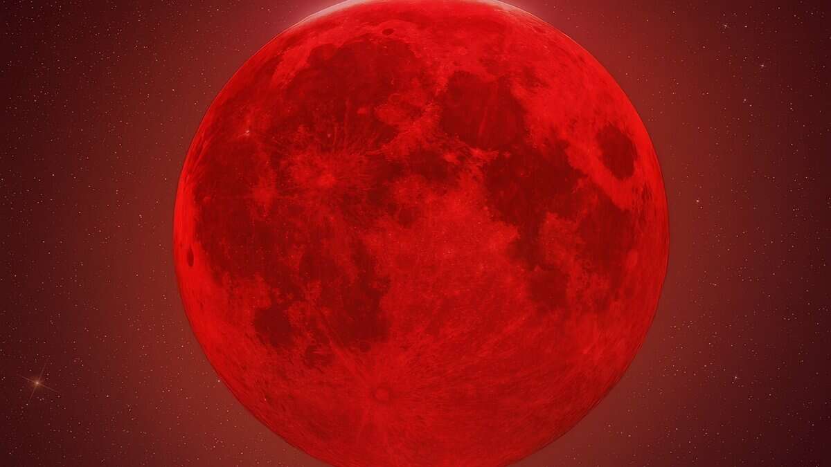 Blood moon during a total lunar eclipse glowing red against a starry night sky.