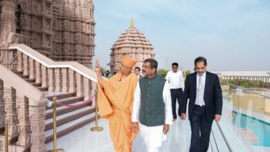 Union Minister Dharmendra Pradhan visits the intricately carved BAPS Hindu temple in Abu Dhabi, guided by a BAPS swami, with other officials walking alongside.