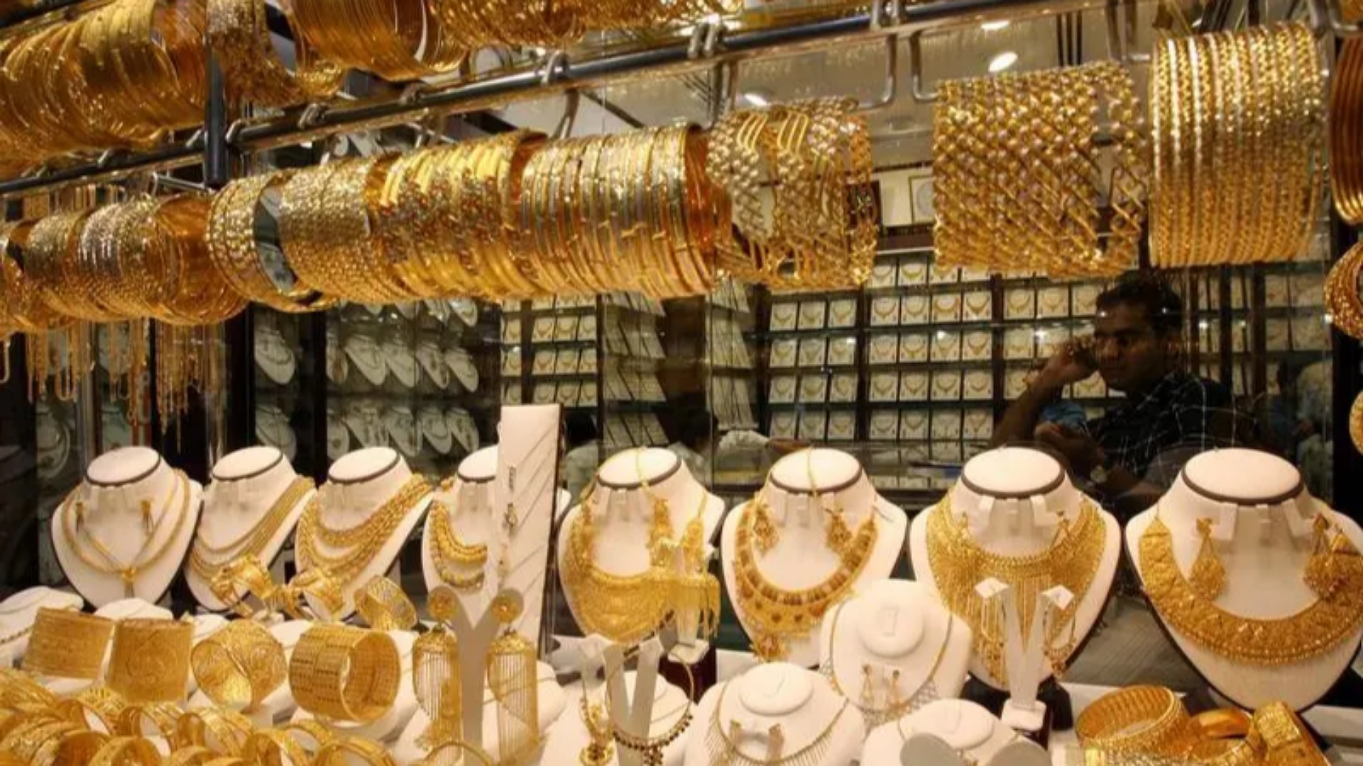 A display of gold jewelry including necklaces, bangles, and bracelets in a shop at the Dubai Gold Souk.