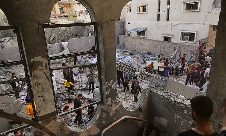 Palestinians gather among rubble after an Israeli airstrike in central Gaza.