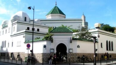 The Grand Mosque of Paris with its white walls, green-tiled roof and traditional Islamic architecture on a bright day.