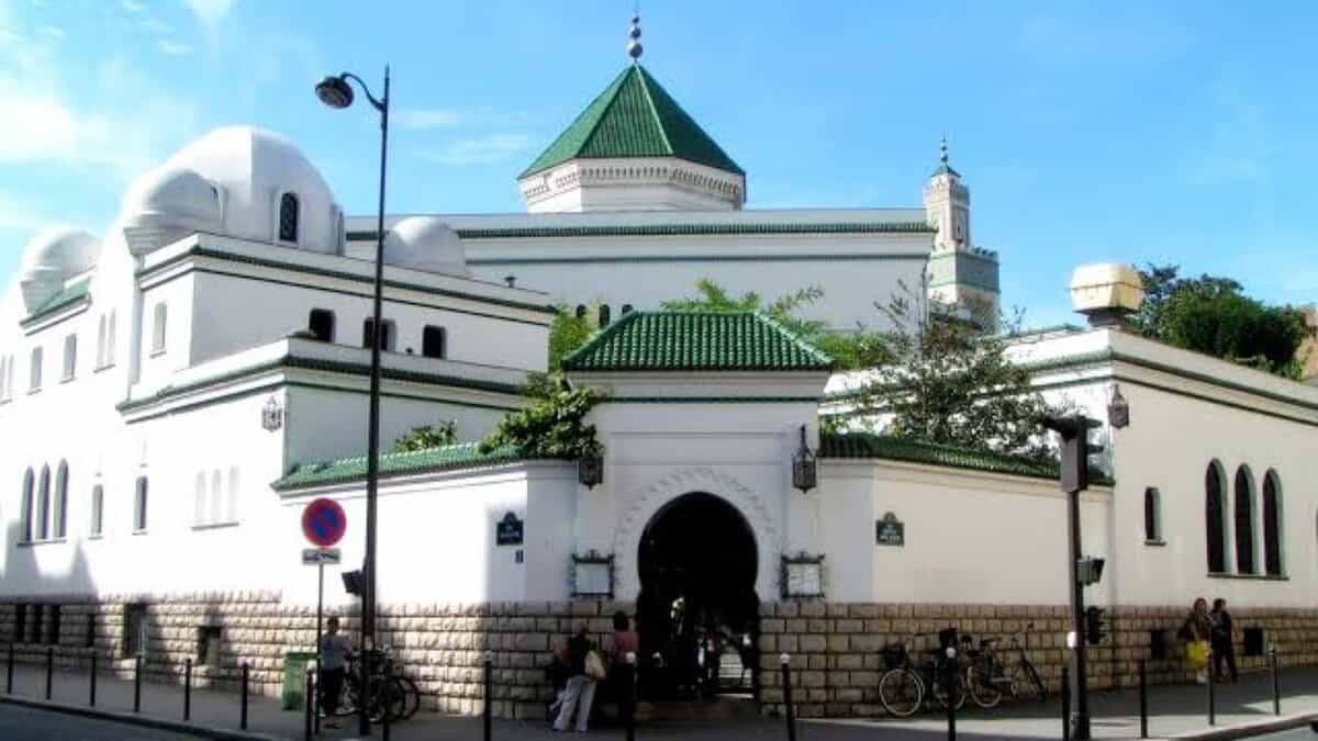 The Grand Mosque of Paris with its white walls, green-tiled roof and traditional Islamic architecture on a bright day.