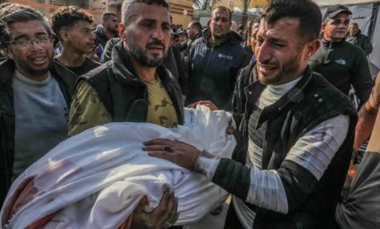Grieving Palestinian men carry the body of a child killed in an Israeli strike in Gaza.