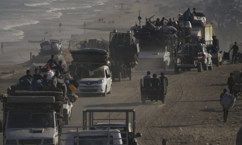 Displaced Palestinians travel by vehicles and carts along Gaza’s coastal road, carrying belongings as they flee south.