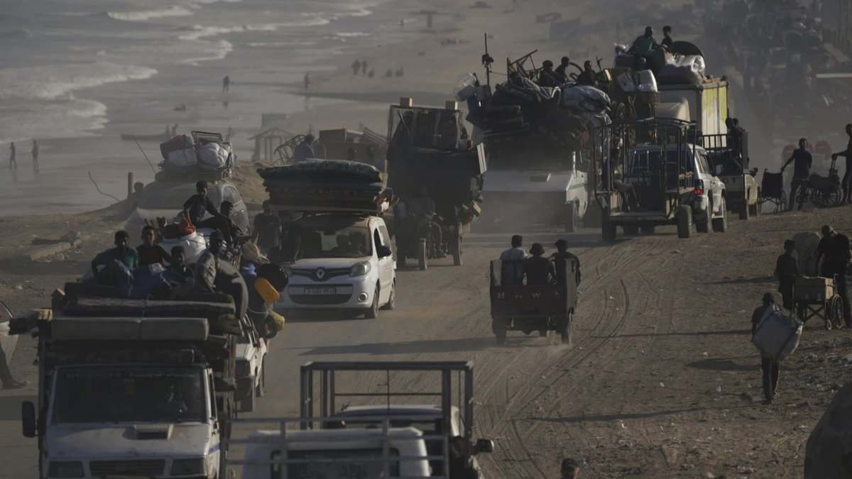 Displaced Palestinians travel by vehicles and carts along Gaza’s coastal road, carrying belongings as they flee south.