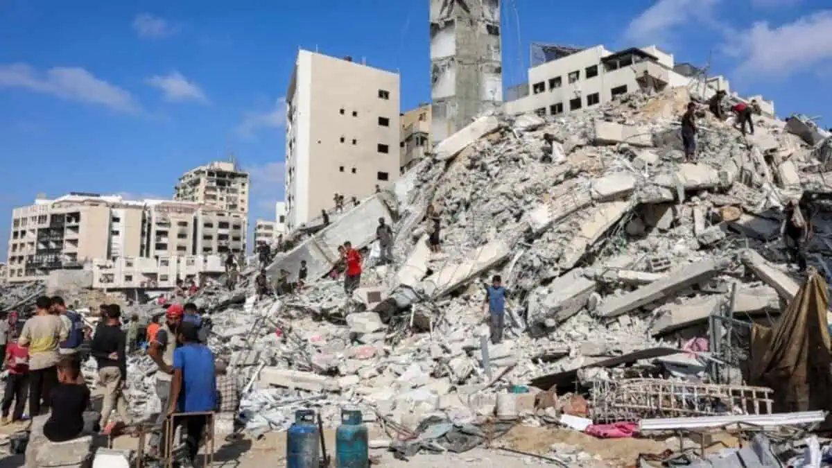 People search through rubble after the destruction of the al-Sousi Tower in Gaza City.
