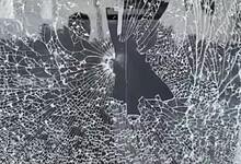 The image shows the glass of Pavan Nexa showroom in Nalgonda town being vandalised by a BJP worker during BC bandh on Saturday, October 18, 2025.