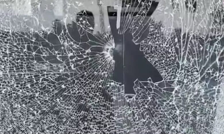 The image shows the glass of Pavan Nexa showroom in Nalgonda town being vandalised by a BJP worker during BC bandh on Saturday, October 18, 2025.