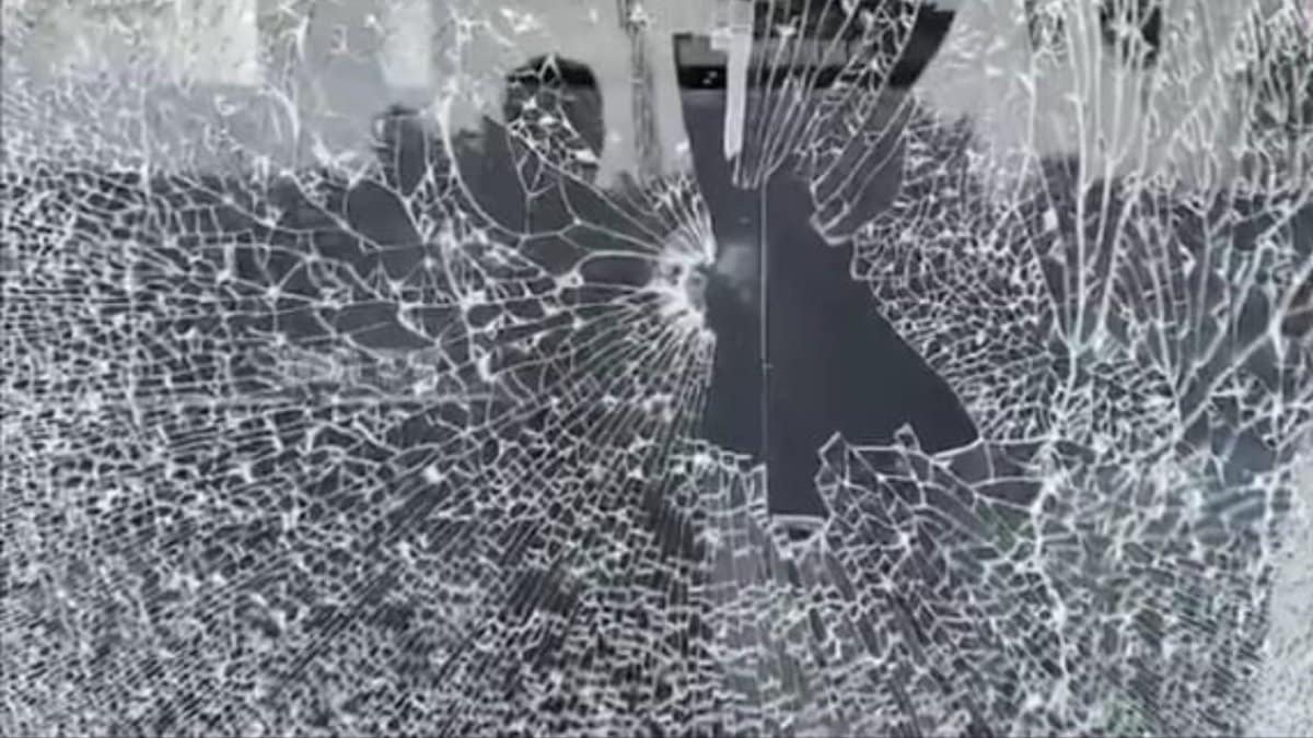 The image shows the glass of Pavan Nexa showroom in Nalgonda town being vandalised by a BJP worker during BC bandh on Saturday, October 18, 2025.
