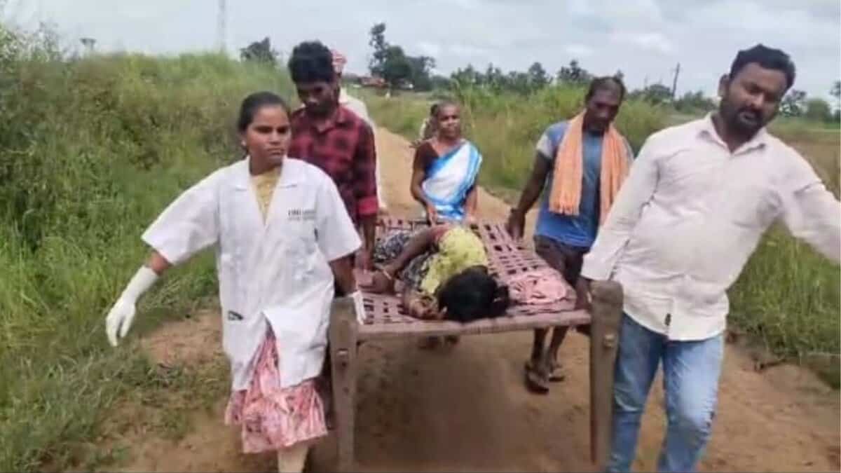 108 ambulance team carry a heavily pregnant Gotti Koya woman on a cot
