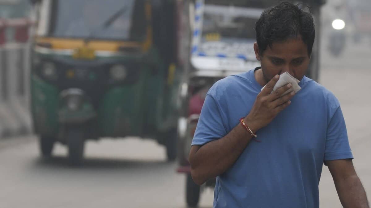 A commuter covers his face while making his way amid low visibility as air quality deteriorates across Delhi-NCR, in New Delhi, Tuesday, Oct. 21, 2025. (PTI Photo/Shahbaz Khan)