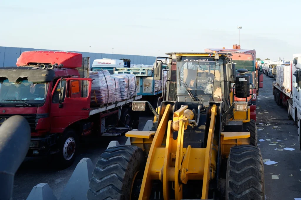 Trucks and bulldozers loaded with aid supplies line up at the Rafah crossing before entering Gaza following a ceasefire.