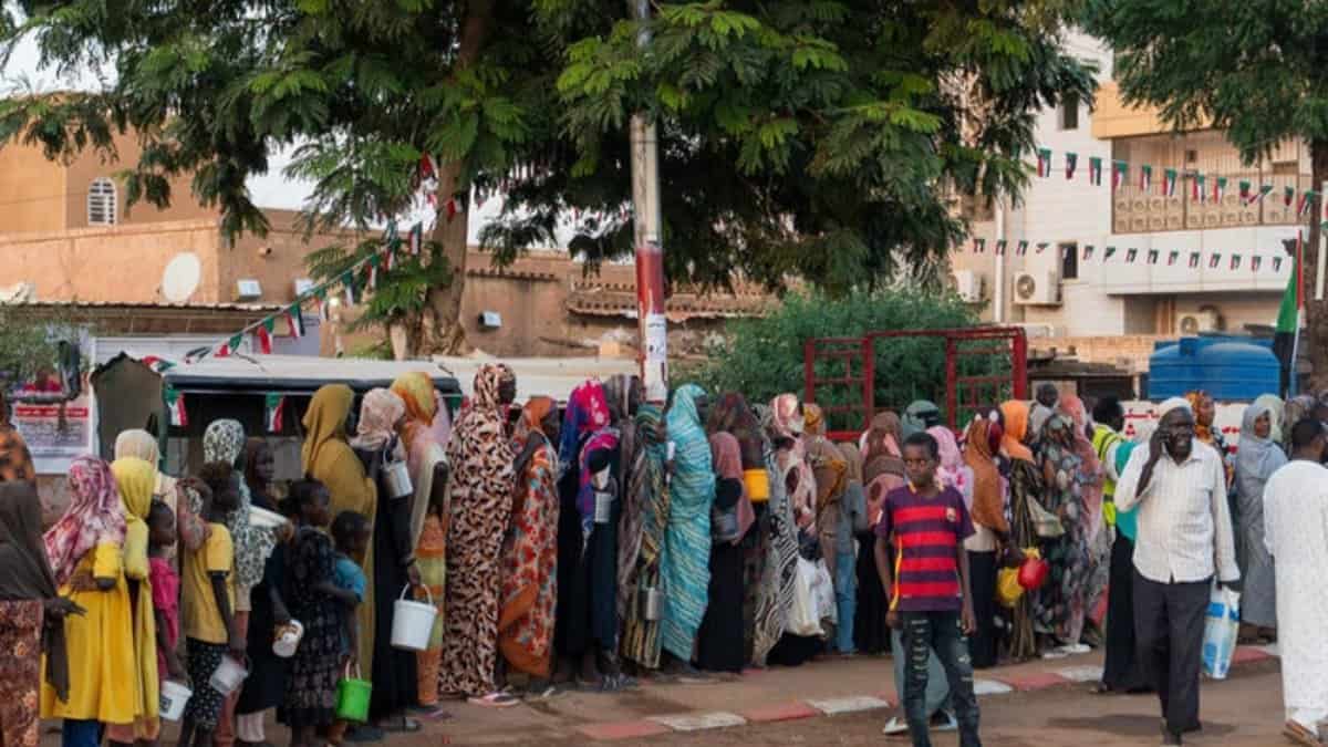 Recently displaced families from El-Fasher queue for food aid in Omdurman, Sudan.