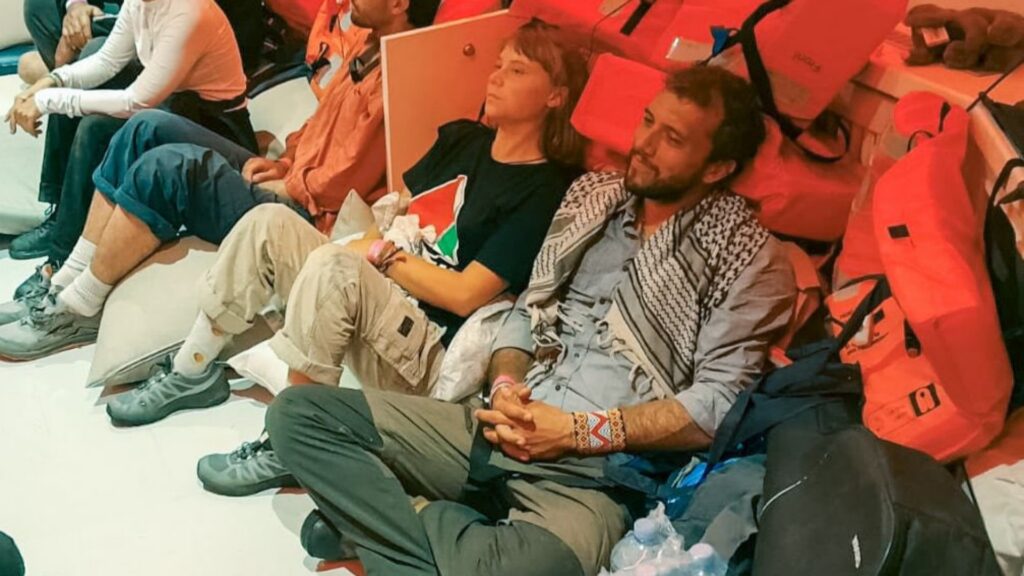 A group of Global Sumud Flotilla activists sit on the floor inside a vessel after being intercepted by Israeli forces.