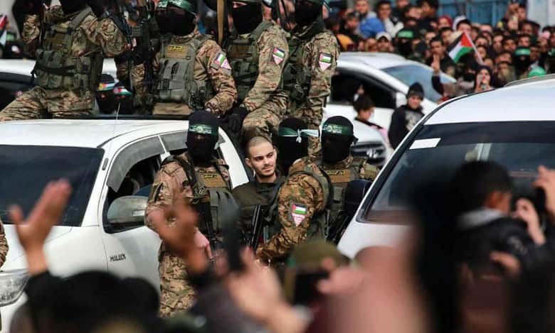 Hamas militants escort a captive during a public rally in Gaza.