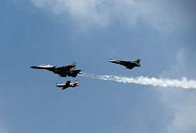Indian Air Force fighter jets performing in formation during a flight demonstration.